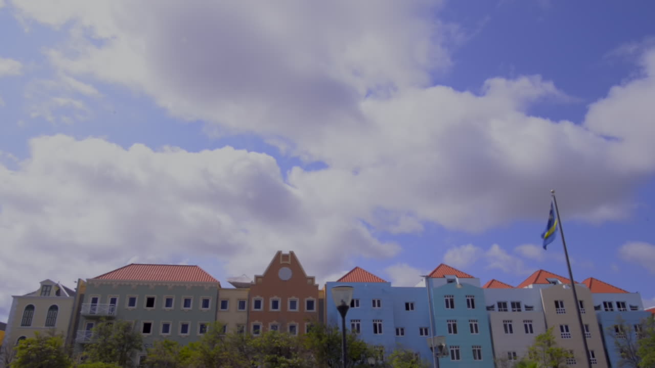 Willemstad dutch architecture colorful houses cityscape with flag on sunny day. Curaçao island building