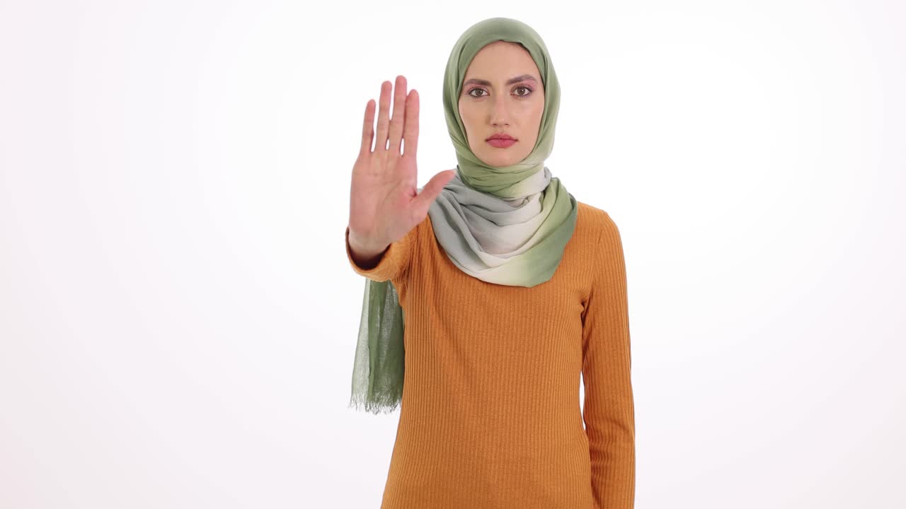Donna con hijab che fa un gesto di stop