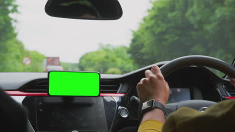 close up of female driver with hands free unit for green screen mobile phone mounted on dashboard