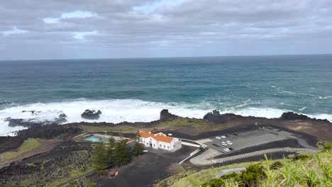 view of the ponta da ferraria hot springs, overlooking the dramatic coastline of são miguel island, azores. the powerful waves of the atlantic ocean meet the rugged landscape, a serene atmosphere.