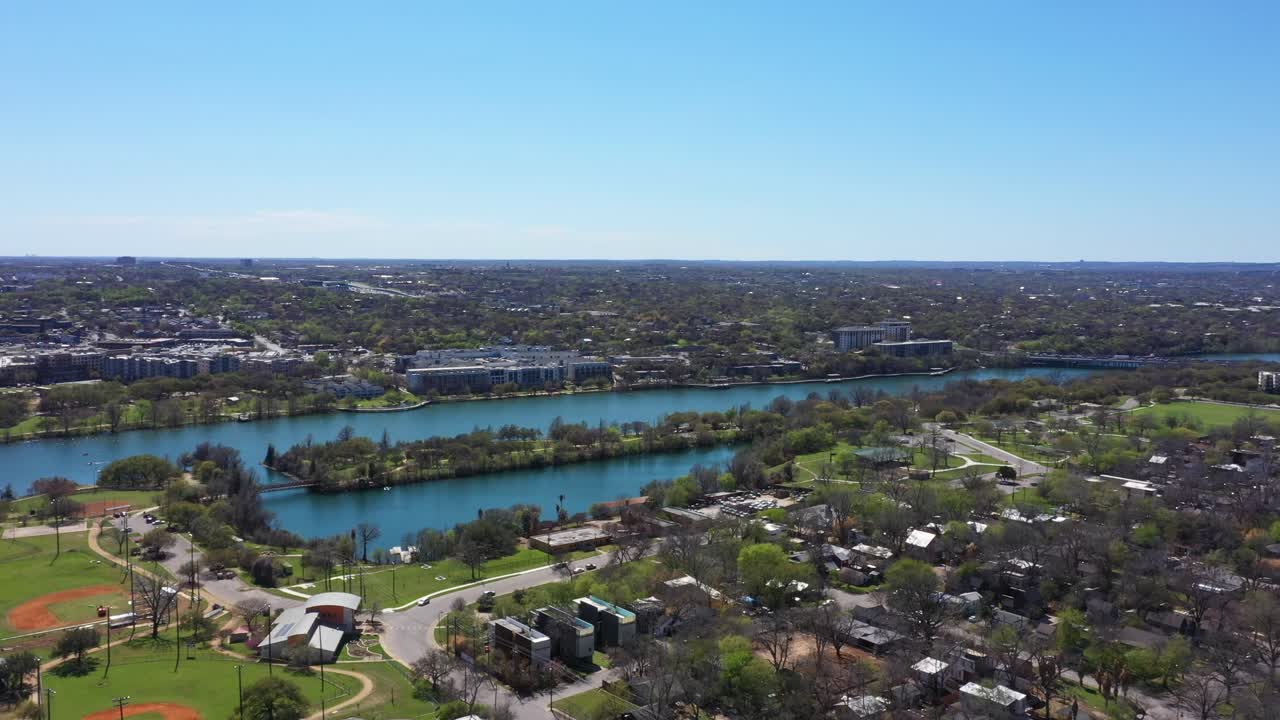 Drone flies toward the river in the city