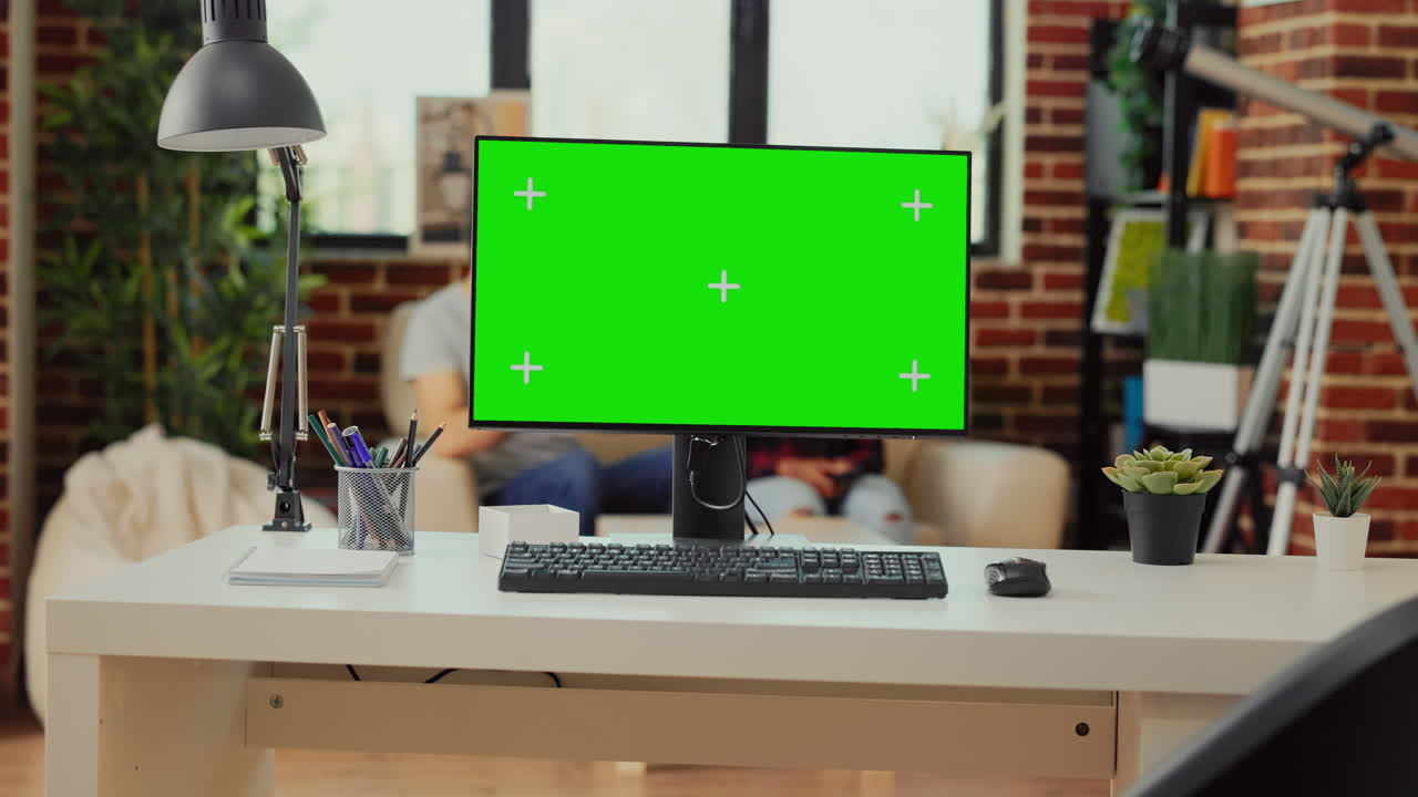 Empty office desk with greenscreen display on computer