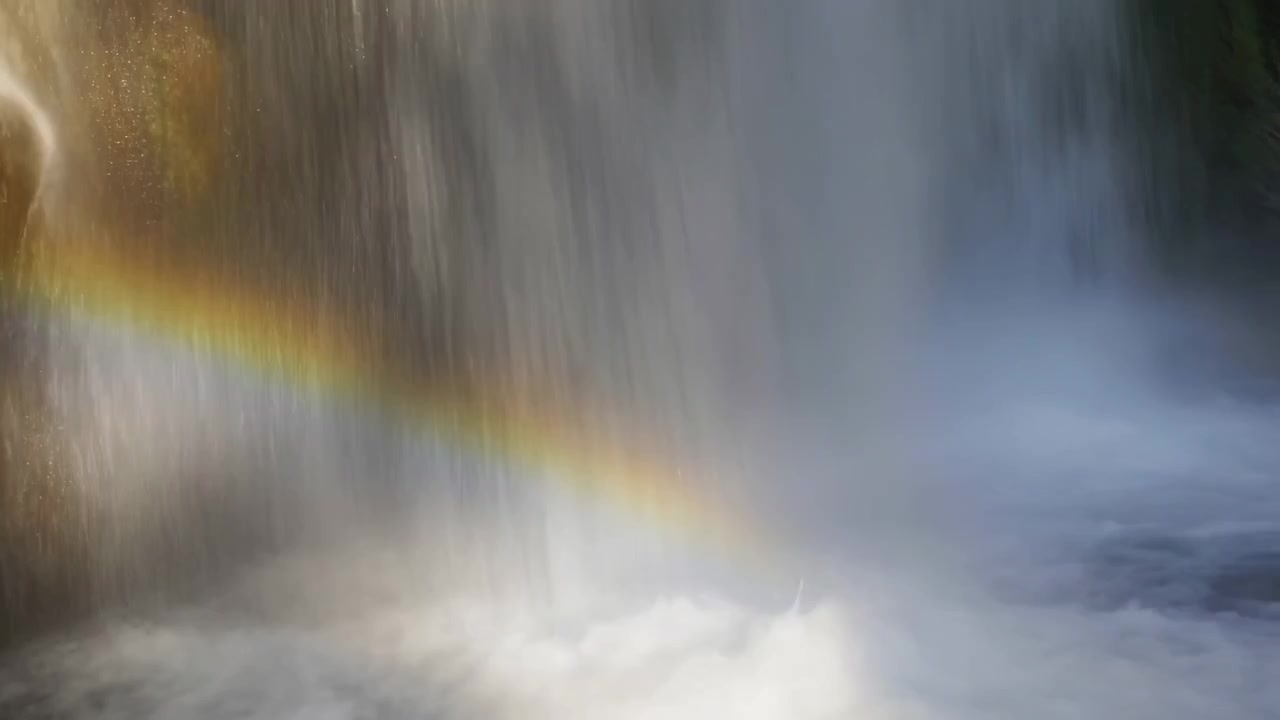 Cortina de cachoeira vertical despeja-se em uma piscina espumosa e turbulenta com névoa densa, borrifo iluminado pelo sol, textura de rocha molhada, arco-íris fraco, musgo exuberante e água corrente poderosa em paisagem externa serena.