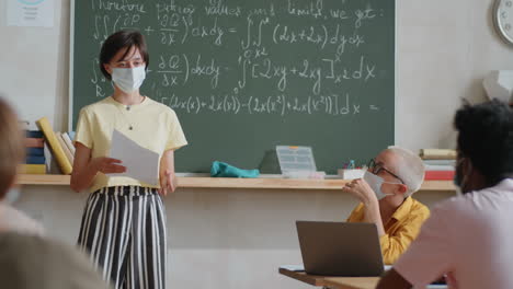 Female-Student-in-Protective-Mask-Reciting-Lesson-in-Classroom