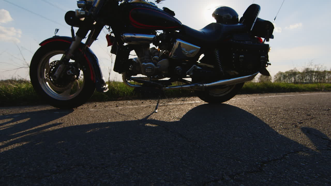 자전거 타는 사람은 오토바이에 앉아 헬멧을 쓰고 태양 광선이 아름다운 r을 주는 카메라에 빛난다