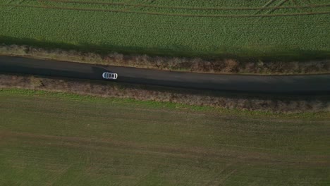 top down drone shot of a white car in a uk road