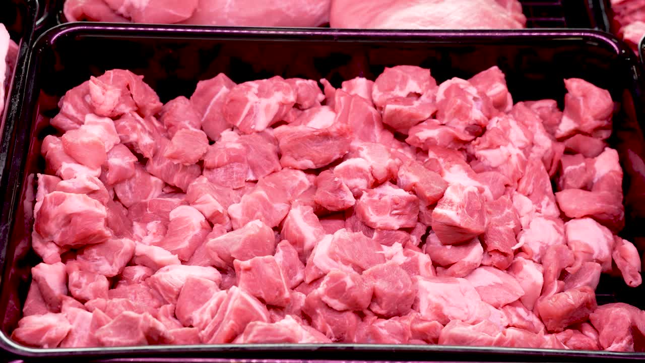 Early weekend morning captures a local market alive with energy, featuring vibrant displays of freshly cut meat. Shoppers browse, selecting the best cuts for their meals