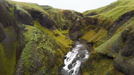 un desfiladero rocoso con musgo y líquenes que conduce a la cascada de stjornarfoss