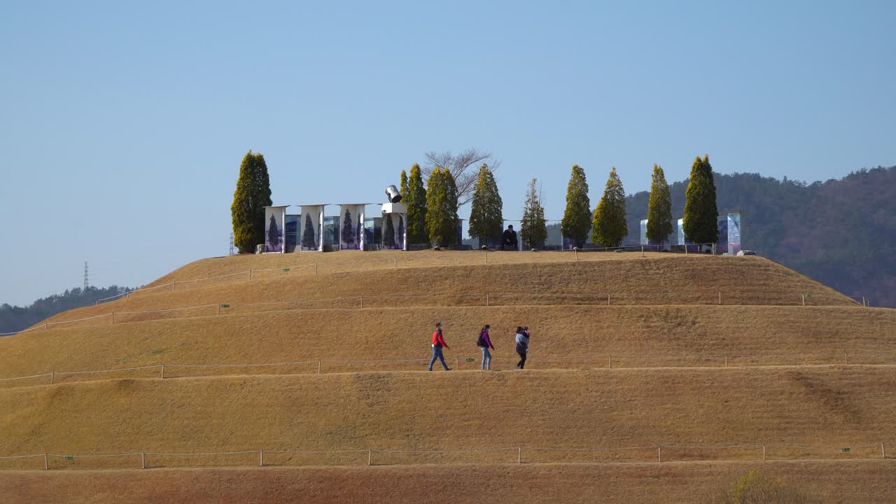 한국 순천만 국립정원의 호수정원에 있는 나선형 보도를 따라 봉화언덕을 걸어가는 사람들 - 정적 스카이라인