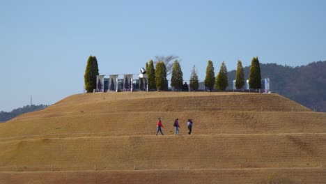 Grupo-De-Personas-Caminando-Por-La-Colina-Bonghwa-En-Un-Sendero-En-Espiral-En-El-Jardín-Del-Lago-Del-Jardín-Nacional-De-La-Bahía-De-Suncheonman,-Corea-Del-Sur---Horizonte-Estático