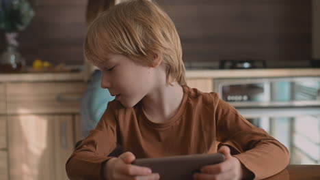 Niño-Pequeño-Y-Hermana-Mayor-Viendo-El-Teléfono-Inteligente-En-Casa