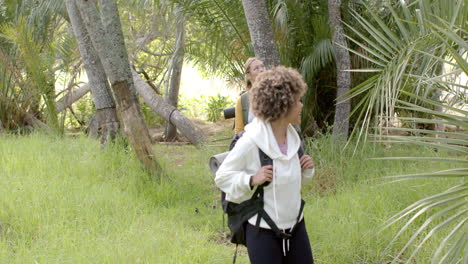 Young-Caucasian-woman-smiles-in-the-background-with-copy-space-as-a-young-biracial-woman-walks-ahead