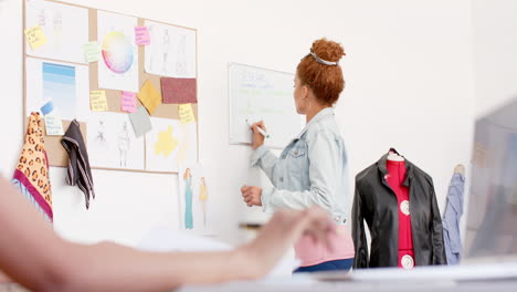 Fröhliche,-Vielfältige-Modedesignerinnen,-Die-Im-Studio-Mit-Laptops-Diskutieren,-Zeitlupe