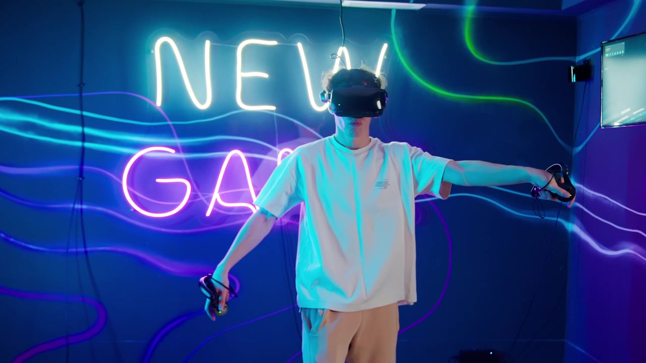 Giovane uomo gioca a un gioco di realtà virtuale con controller in una stanza illuminata al neon