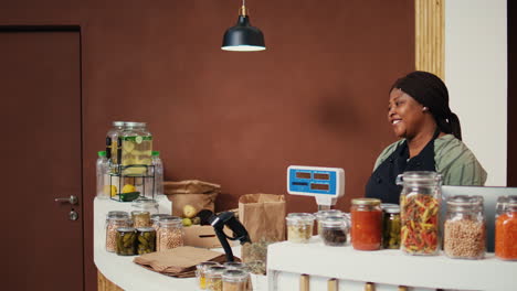 cliente comprando varias pastas y granos en frascos en una tienda orgánica