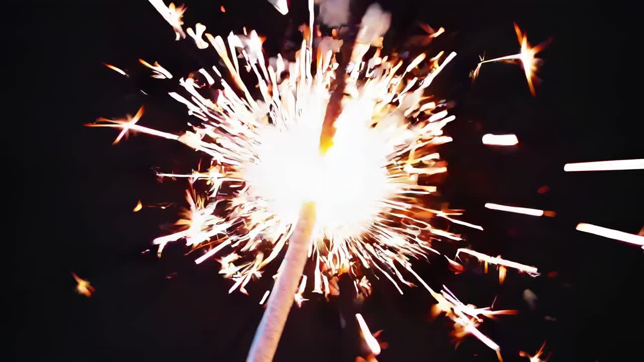 Close-up, angled shot of a sparkler igniting against a dark background, capturing dynamic sparks