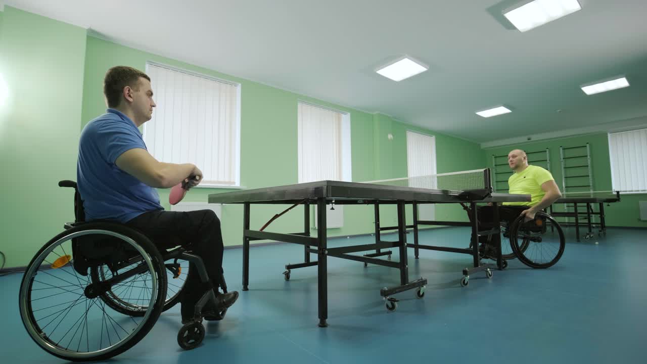 un hombre en silla de ruedas juega al ping-pong. personas con discapacidad juegan al tenis de mesa. rehabilitación de discapacitados. deporte.