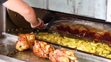 chicken and potatoes roasting in a rotisserie oven