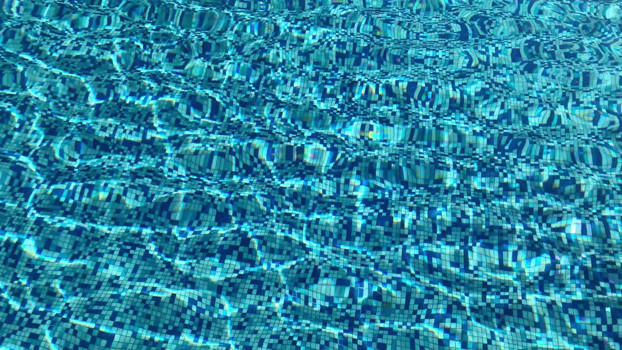 Air jernih sebening kristal di kolam renang dengan sinar matahari membentuk bayangan di air dan di lantai keramik - latar belakang bertekstur