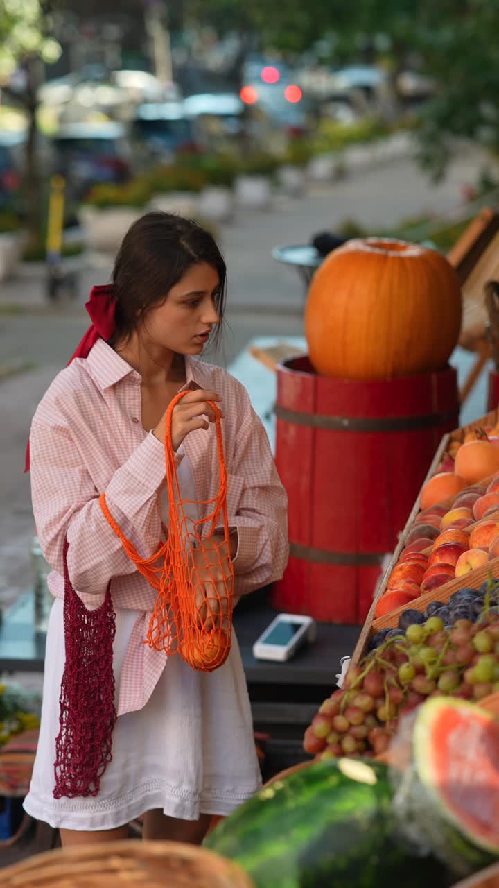 mujer comprando frutas en un mercado al aire libre
