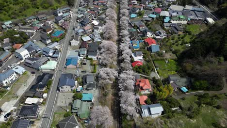 slow cinematic drone backward tilt up over beautiful rural village in japan
