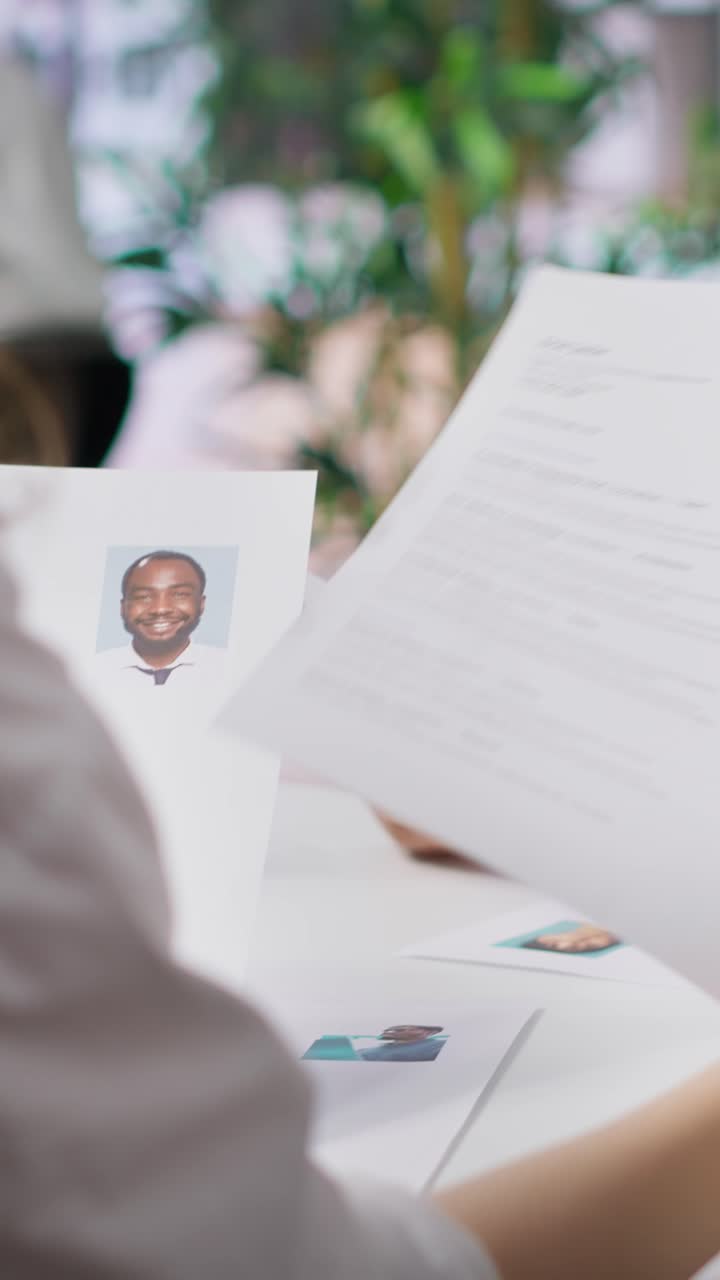 Vertical Video Human resources staff evaluating candidates resume in the selection process
