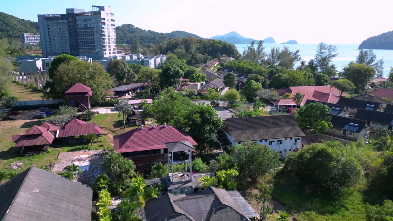 Nice aerial view flight . Elevated shot showcasing a serene beach resort with inviting swimming pool surrounded by lush greenery and traditionalstyle buildings. ascending drone