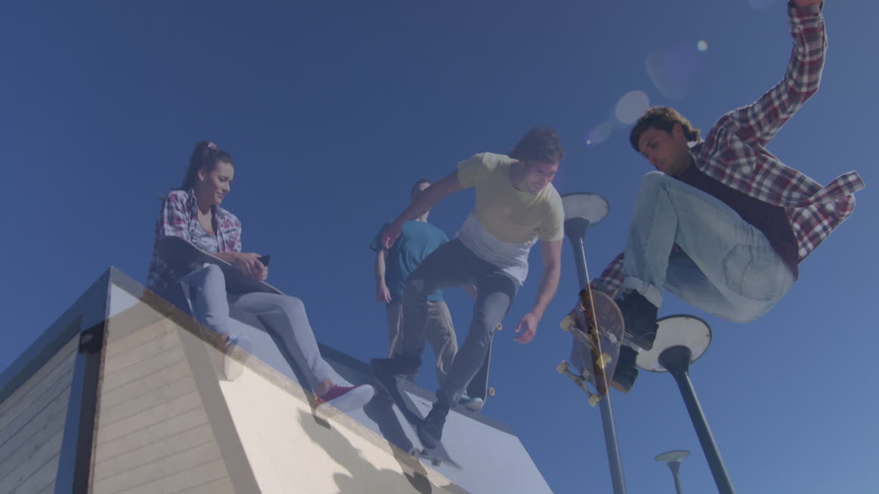 Composite video of tall building against group of friends skateboarding in the park