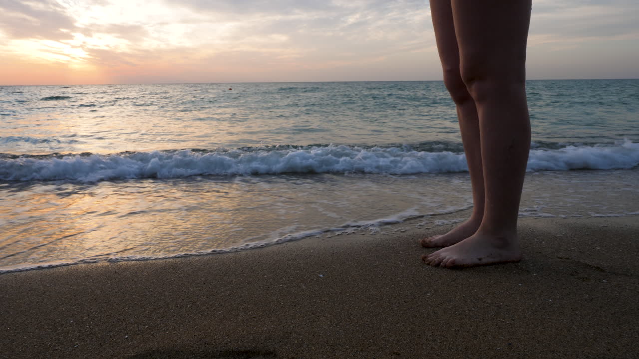 Close up woman feet walking on the beach in the water