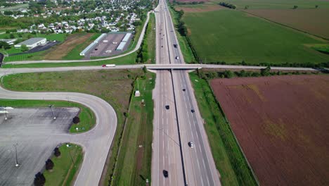 Red-Semi-Truck-driver-with-white-trailer-driving-on-bridge-overpass-above-Interstate-I-90-Illinois-Belviedere