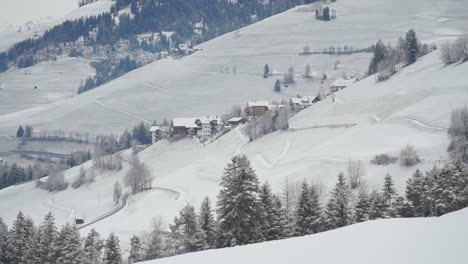Scattered homes stand out on the snow-covered slope in the stillness of winter in the Italian Alps.