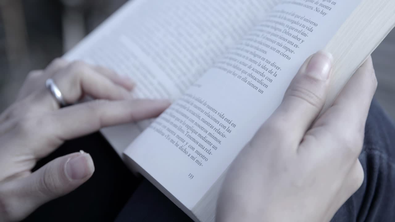 Close-up of Hands Reading a Book and Turning Pages