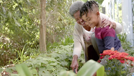 happy african american mother, son and grandmother gardening together, copy space, slow motion