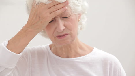 una anciana con dolor de cabeza.