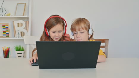 little boy and girl using a laptop and having fun at home 1