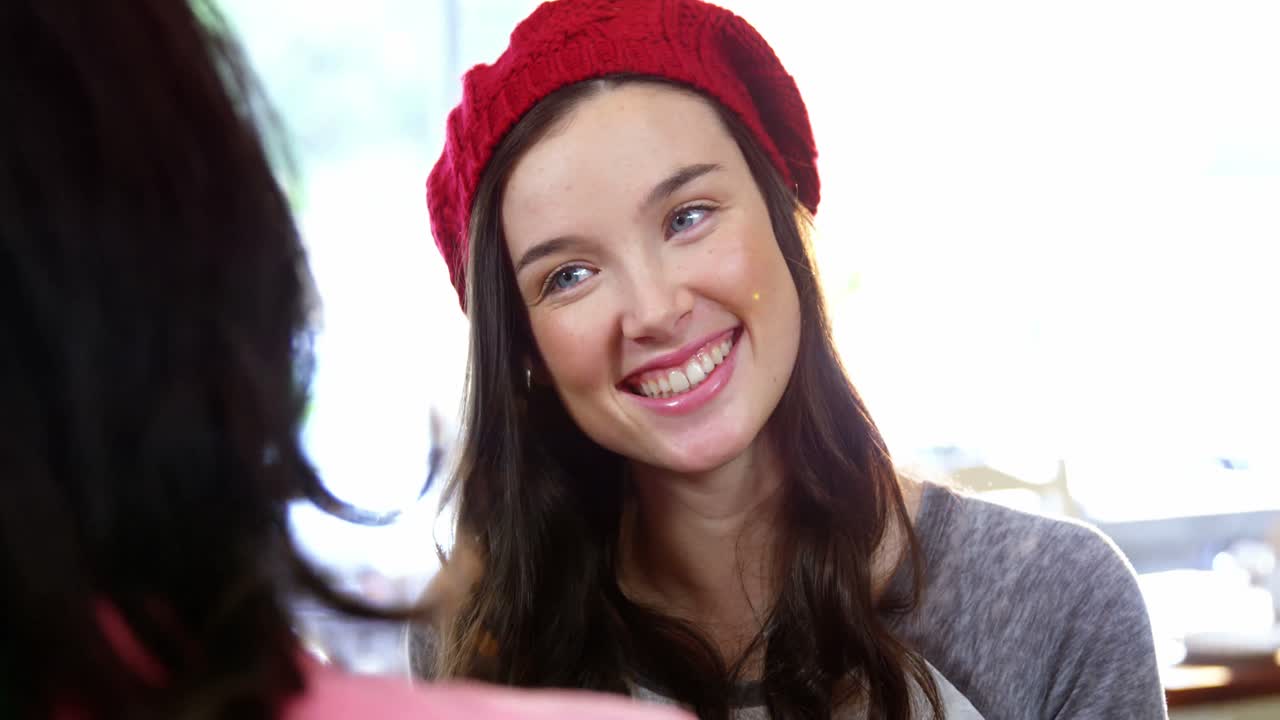 mujer sonriendo mientras interactúa con un amigo