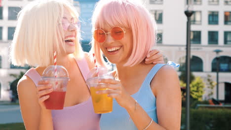 two happy friends enjoying drinks in the city