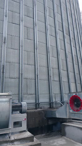 large silver granary. storage of grain in the background of winter. vertical video