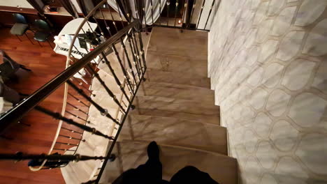 first-person slow motion view of walking down stairs in a restaurant, looking downward.
