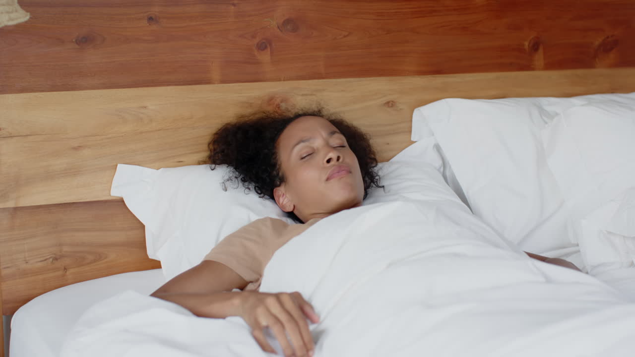 Relaxing in bed, thoughtful woman lying under white sheets, enjoying morning, at home