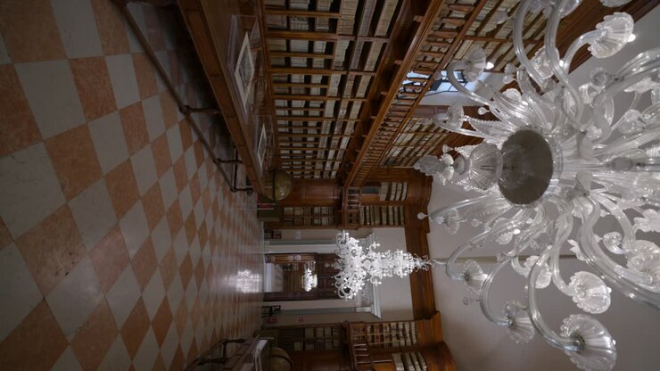 Biblioteca Teresiana Mantova | Antica biblioteca in legno con grandi lampadari di cristallo