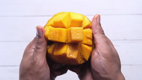 mango en rodajas en las manos