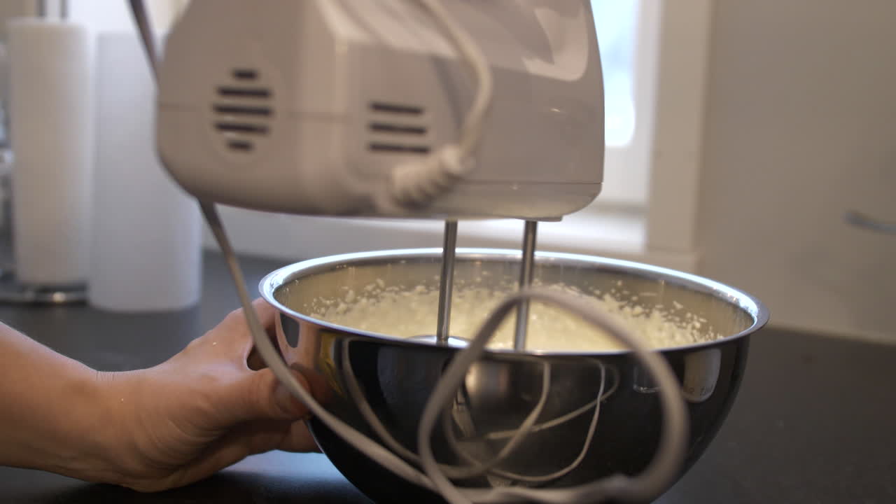 крупный план человека, делающего взбитые сливки с помощью электрического ручного миксера