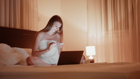 mujer relajándose y usando dispositivos en la cama por la noche
