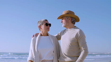 senior couple walking along seashore.