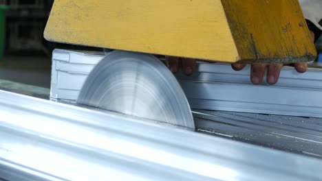 circular saw cutting through stainless steel in a metal factory