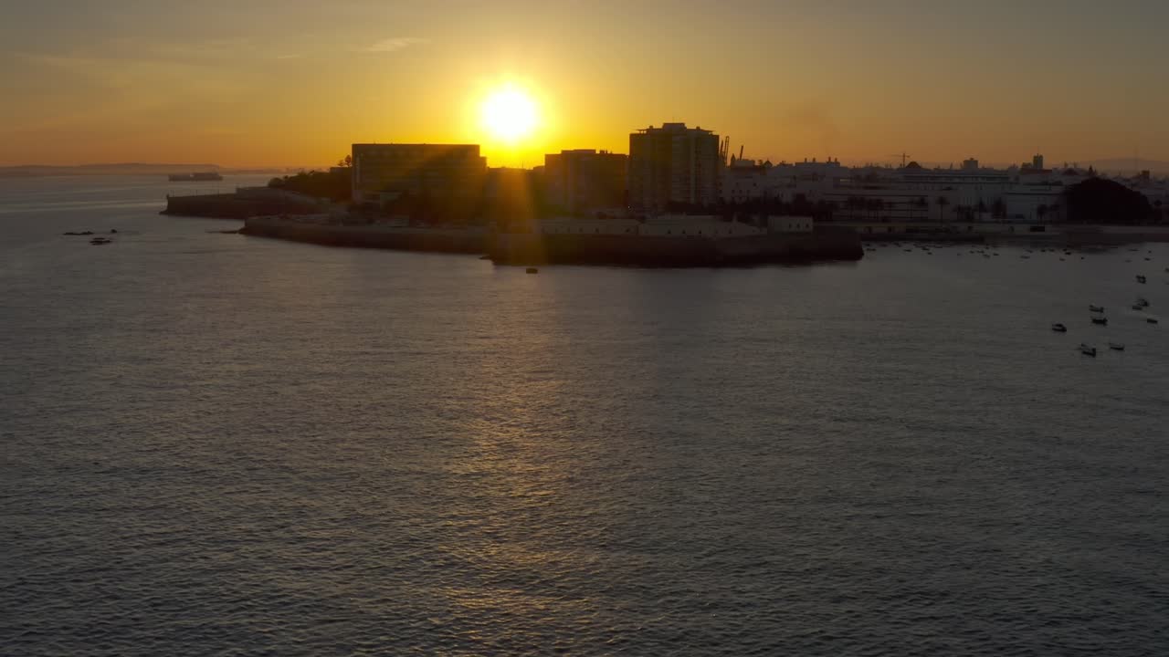Sunset over coastal city with boats