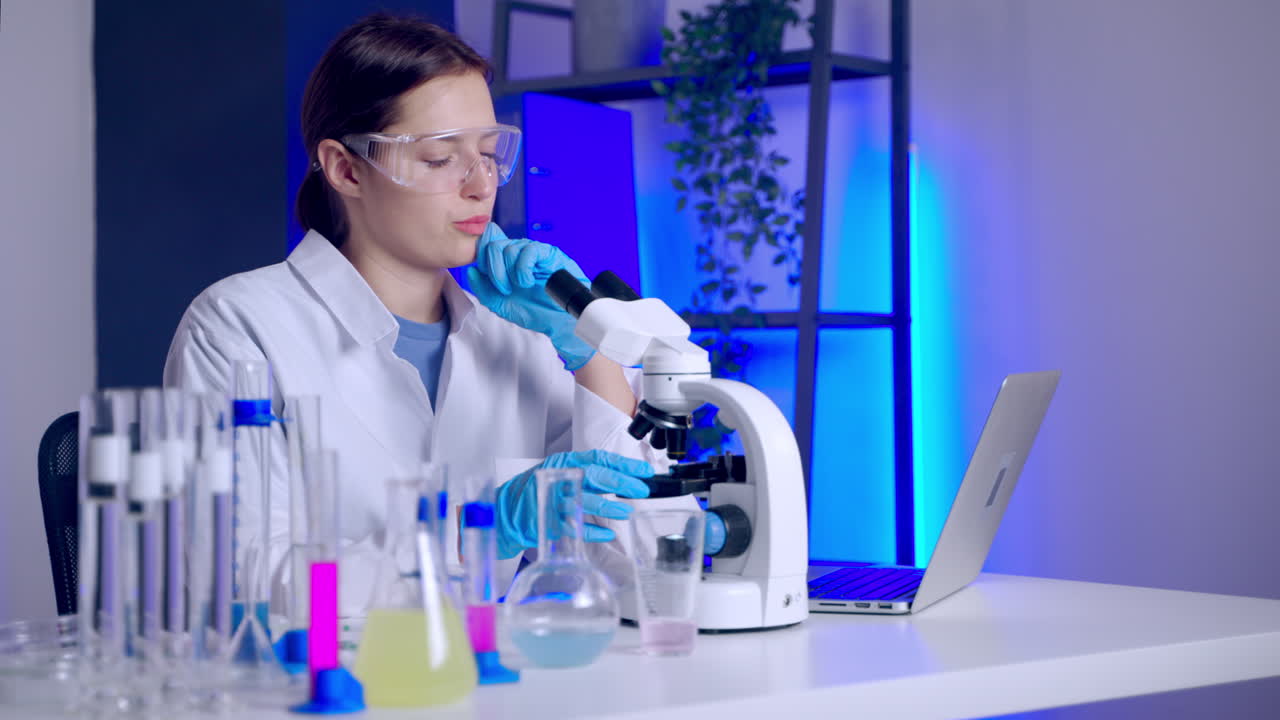 científico usando el microscopio en un laboratorio