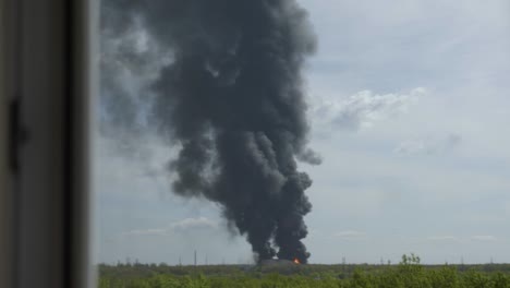 a giant fire and a column of black smoke after the explosion at the oil storage.