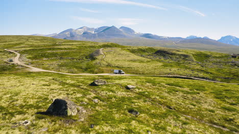 aerial view of the campcar on the dirt path of the green valley in rondane national park